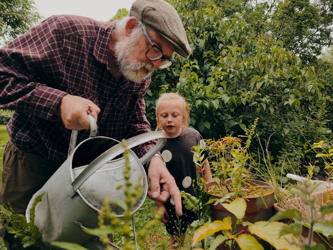 a-man-and-a-child-looking-at-a-plant-nc-hc5g5yhw